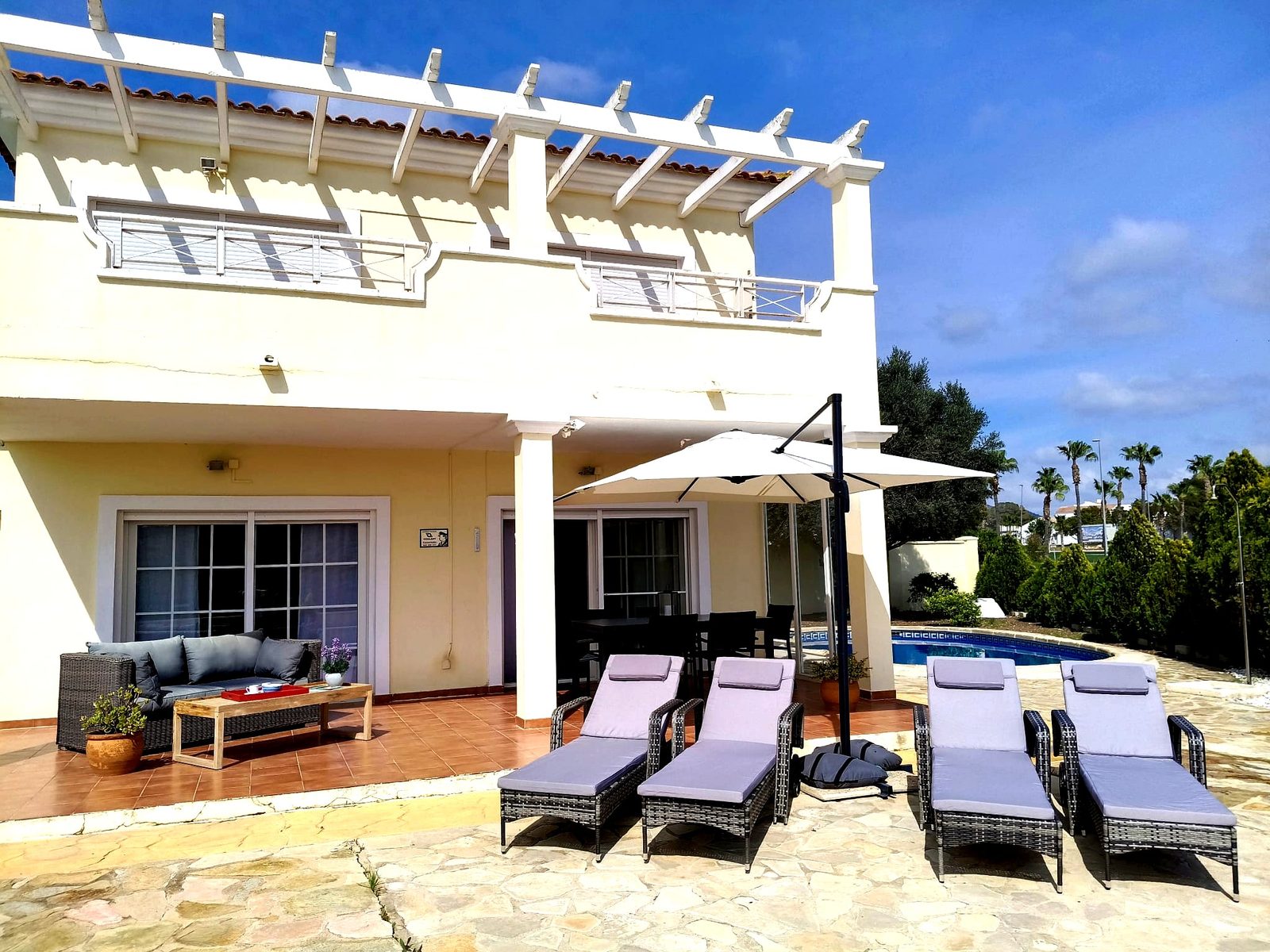 Villa met ligbedden bij het zwembad in Villa Elegante